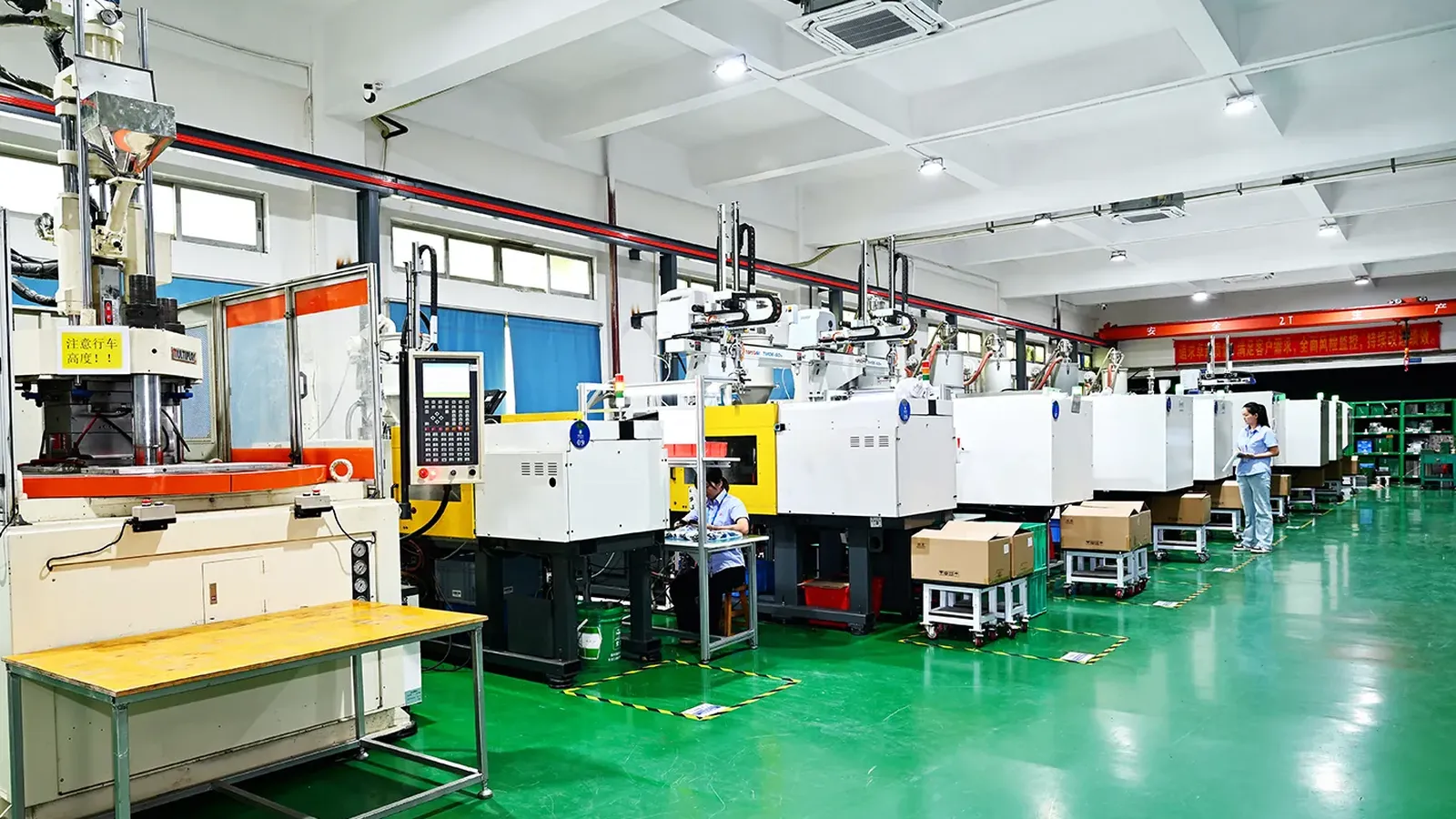 Automated injection molding presses with robotic take-out arms running on our production floor