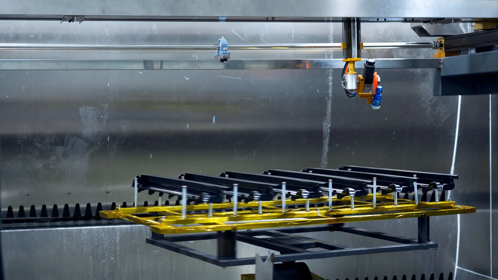 Robot arm unloading finished parts from the coating line
