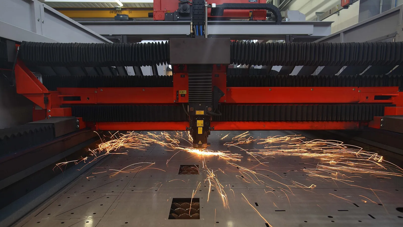 Fiber laser head cutting sheet metal with a spark jet